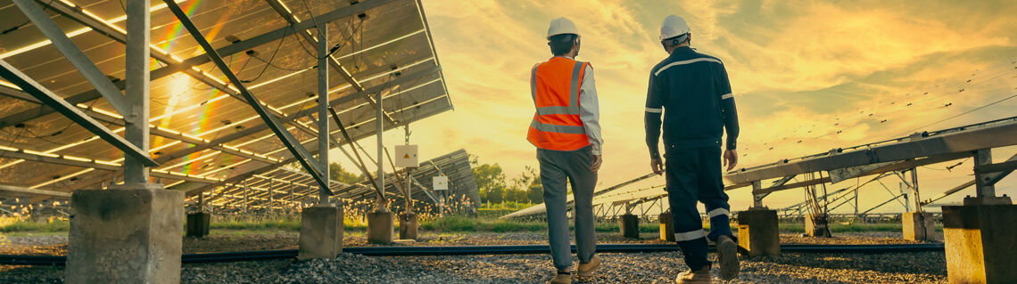 Two project managers walking while walking by solar panels